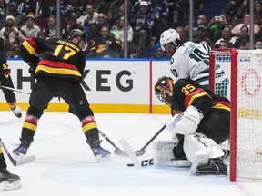 Vancouver Canucks goalie Thatcher Demko (35) stops San Jose Sharks' Anthony Duclair (10) as Vancouver's Filip Hronek (17) watches during the first period.