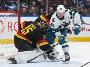 Vancouver Canucks goalie Thatcher Demko (35) is interfered with by San Jose Sharks' Fabian Zetterlund (20) during the second period of an NHL hockey game on Monday night at Rogers Arena.