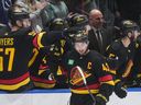 Canucks captain Quinn Hughes gets a celebratory tap from teammate Tyler Myers after scoring the opening goal Monday against the San Jose Sharks at Rogers Arena.