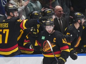 Vancouver Canucks' Quinn Hughes, front right, and Tyler Myers celebrate Hughes' goal against the San Jose Sharks during the second period on Monday night at Rogers Arena