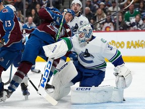 Colorado Avalanche right wing Mikko Rantanen, left, gets entangled with Vancouver Canucks goaltender Thatcher Demko during the first period on Wednesday night in Denver.