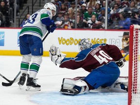 Colorado Avalanche goaltender Alexandar Georgiev, right, makes a glove save against Vancouver Canucks centre Teddy Blueger during the second period on Wednesday night in Denver.