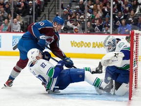 Colorado Avalanche forward Riley Tufte scores the go-ahead goal early in the third period as Vancouver Canucks defenceman Ian Cole and goaltender Thatcher Demko try to make a stop on Wednesday night in Denver.