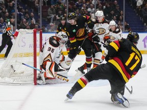 Vancouver Canucks' Brock Boeser, back centre, scores against Anaheim Ducks goalie John Gibson (36) as Pavel Mintyukov (34) watches during the first period on Tuesday at Rogers Arena