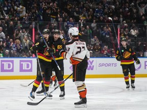 Elias Pettersson, back left, and Ilya Mikheyev celebrate Pettersson's goal as Quinn Hughes, back right, skates to join them during the third period on Tuesday night at Rogers Arena