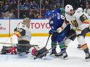 Vegas Golden Knights goalie Adin Hill stops Vancouver Canucks' J.T. Miller as Vegas' Alex Pietrangelo defends during the first period of NHL game in Vancouver, on Thursday, November 30, 2023.