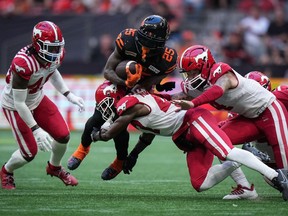 B.C. Lions' Taquan Mizzell (25) is tackled by Calgary Stampeders' Brad Muhammad, front centre, during the second half of a CFL football game, in Vancouver, on Saturday, Aug. 12, 2023. The Lions have had time to think about this one. B.C. (12-6) hosts Calgary (6-12) in the West Division semifinal Saturday, with the winner advancing to the conference final against the Winnipeg Blue Bombers (14-4). The playoff matchup comes after the Stampeders earned a surprising 41-16 road victory over the Lions on Oct. 20.