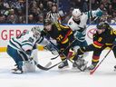 Vancouver Canucks' J.T. Miller (9) scores against San Jose Sharks goalie MacKenzie Blackwood (29) as San Jose's Kyle Burroughs (4) checks Vancouver's Anthony Beauvillier (72) during the third period of an NHL hockey game in Vancouver, on Monday, November 20, 2023.