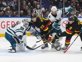Vancouver Canucks' J.T. Miller (9) scores against San Jose Sharks goalie MacKenzie Blackwood (29) as San Jose's Kyle Burroughs (4) checks Vancouver's Anthony Beauvillier (72) during the third period of an NHL hockey game in Vancouver, on Monday, November 20, 2023.