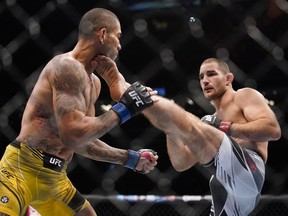 Sean Strickland, right, kicks Alex Pereira in a middleweight bout during the UFC 276 mixed martial arts event Saturday, July 2, 2022, in Las Vegas.