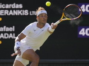 FILE - Spain's Rafael Nadal returns to Lithuania's Ricardas Berankis in a second round men's singles match for the Wimbledon tennis championships in London, June 30, 2022. Nadal is sure he'll be returning to competition after missing nearly all of 2023 with a hip injury that required surgery. And now he says he'll be revealing his comeback plans soon. Nadal wrote Thursday, Nov. 16, 2023 on social media: "I confirmed yesterday I'll be back" and punctuated that message with a smiling emoji.