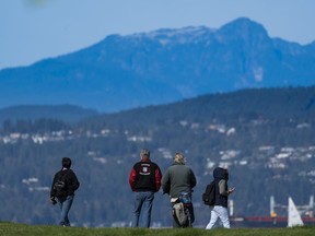 Park goers take in the view of the North Shore mountains on a clear fall day in Vancouver.