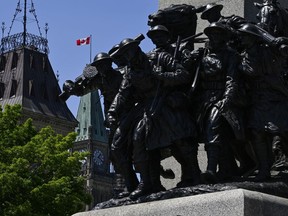 The Peace Tower on Parliament Hill is seen past the National War Memorial in Ottawa, on Canadian Armed Forces Day, Sunday, June 4, 2023.