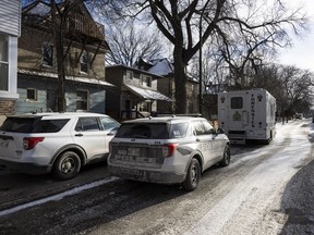 Police vehicles are shown outside the scene of a shooting at a home in Winnipeg on Monday, Nov. 27, 2023.
