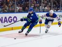 Canucks forward Pius Suter is hounded by Oilers captain Connor McDavid during the Oct.11 season opener at Rogers Arena.