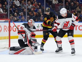 Vitek Vanecek #41 makes a save as Simon Nemec #17 of the New Jersey Devils defends against Andrei Kuzmenko #96 of the Vancouver Canucks during the first period of their NHL game at Rogers Arena on December 5, 2023 in Vancouver, British Columbia, Canada.