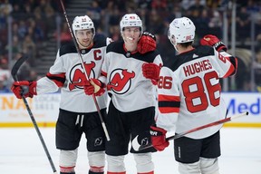 Luke Hughes of the Devils is congratulated by Nico Hischier and Jack Hughes after scoring Tuesday at Rogers Arena.