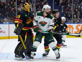 Casey DeSmith #29 and Teddy Blueger #53 of the Vancouver Canucks defends against Pat Maroon #20 of the Minnesota Wild during the second period of their NHL game at Rogers Arena on December 7, 2023 in Vancouver, British Columbia, Canada.