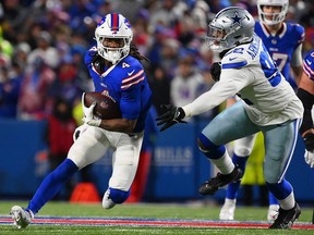 James Cook, left, of the Buffalo Bills runs past Dorance Armstrong of the Dallas Cowboys during the second quarter at Highmark Stadium on Sunday, Dec. 17, 2023, in Orchard Park, N.Y.