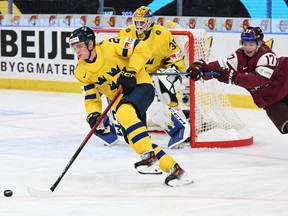 Sweden's Tom Willander (L) and Latvia's Davis Borozinskis (R) vie for the puck during the Group A ice hockey match between Sweden and Latvia of the IIHF World Junior Championship in Gothenburg, Sweden on December 26, 2023.