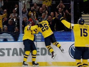Sweden's Otto Stenberg (C) celebrates with Canucks prospect Elias Pettersson after scoring the 1-0 goal during the Group A game between Germany and Sweden in the IIHF World Junior Championship in Gothenburg, Sweden on December 28, 2023.