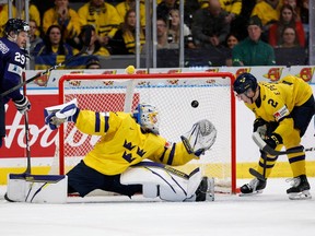 Elias Pettersson watches Finland's forward Lenni Hameenaho's shot go into the net to tie the game 4-4 late in the third period.