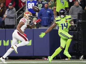 San Francisco 49ers cornerback Charvarius Ward, left, breaks up a pass intended for Seattle Seahawks wide receiver DK Metcalf (14) during the second half of an NFL football game, Thursday, Nov. 23, 2023, in Seattle.