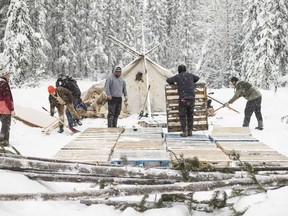 Supporters of the Wet'suwet'en hereditary chiefs and who oppose the Costal GasLink pipeline, work on a support camp just outside of Gidimt'en checkpoint near Houston B.C., on Thursday, Jan. 9, 2020. A report by Amnesty International says police in British Columbia conducted arbitrary arrests and "aggressive surveillance, harassment and intimidation" of First Nations protesters blocking a pipeline project.