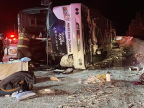 First responders look over the scene of a bus crash on Highway 97C Okanagan Connector between Merritt and Kelowna in this Saturday, Dec. 24, 2022 handout photo. The BC Prosecution Service says there will be no charges stemming from the Christmas Eve 2022 bus crash that claimed four lives.
