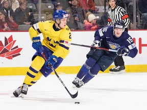 Sweden's Elias Pettersson looks up ice to make a pass as Finland's Lenni Hameenaho gives chase during second period IIHF World Junior Hockey Championship quarterfinal hockey action in Moncton, N.B., on Monday, January 2, 2023.