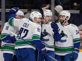 Vancouver Canucks center Nils Aman, second from right, celebrates a goal with teammates Sam Lafferty (18), Ian Cole (82) and Phillip Di Giuseppe (34) during the first period of an NHL hockey game against the Nashville Predators, Tuesday, Dec. 19, 2023, in Nashville, Tenn.