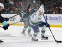 Vancouver Canucks forward Linus Karlsson carries the puck as Seattle Kraken forward Morgan Geekie and defenseman Vince Dunn, front left, give chase during the first period of a preseason NHL game Saturday, Oct. 1, 2022, in Seattle.