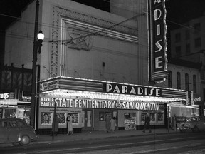 John McGinnis photograph of the Paradise Theatre Marquee, 851 Granville St., in Vancouver in October 1950. The double bill is State Penitentiary and San Quentin, two prison-themed movies. The front of the theatre has been done up like a prison for the occasion, with faux brick or stone walls and prison bars over some of the posters/lobby cards for the movies.
