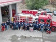 Members of the Wilson's Landing, B.C., Fire Department pose for a group photo in a September 2023, handout image, about three weeks after a fast-moving wildfire swept through their small community on the shores of Okanagan Lake, near West Kelowna, B.C.