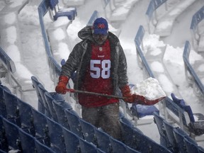 A worker helps remove snow from Highmark Stadium in Orchard Park, N.Y., on Sunday.
