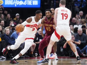 RJ Barrett (9) of the Toronto Raptors drives against Donovan Mitchell (45) of the Cleveland Cavaliers during the first half of their basketball game at Scotiabank Arena on Monday, Jan. 1, 2024, in Toronto.