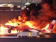 This photo provided by Jiji Press shows a Japan Airlines plane on fire on a runway of Tokyo's Haneda Airport on January 2, 2024.