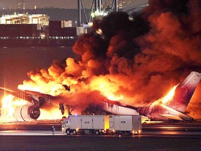 This photo provided by Jiji Press shows a Japan Airlines plane on fire on a runway of Tokyo's Haneda Airport on January 2, 2024.