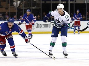 Elias Pettersson watches his empty net goal as Adam Fox of the New York Rangers defends during the third period at Madison Square Garden on Monday night.