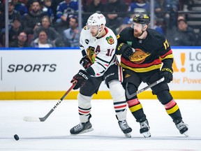 Filip Hronek defends Chicago Blackhawks forward Jason Dickinson during the first period at Rogers Arena on Monday night.