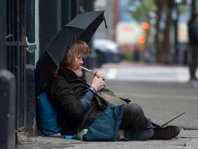 A man smokes from a drug pipe on Columbia Street in Vancouver in a file photo from April 20, 2023. The B.C. Supreme Court ruling allowing for unrestricted drug use in public spaces was based on faulty logic, argues columnist Adam Zivo.
