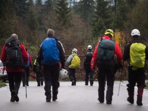 The former head of the B.C. Search and Rescue Association says volunteer search and rescue personnel have been bullied, threatened and disrespected by the province's Ministry of Emergency Management and Climate Readiness. Search and rescue volunteers exit a trail on Eagle Mountain in Coquitlam, B.C., Wednesday, Nov. 22, 2017.