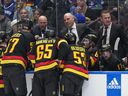 Head coach Rick Tocchet (middle) and assistant coach Adam Foote (right) listen as assistant coach Mike Yeo talks to the players during a game against the San Jose Sharks last month.