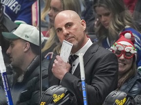 Vancouver Canucks head coach Rick Tocchet stands behind the bench in late September.