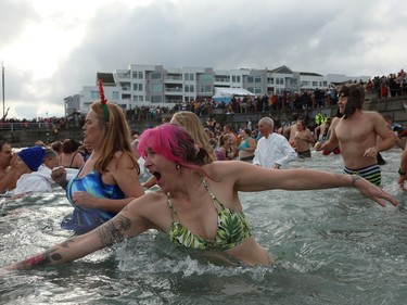 Hundreds of people take part in the annual polar bear swim to ring in the new year at Glass Beach in Sidney, B.C., on Monday, January 1, 2024.