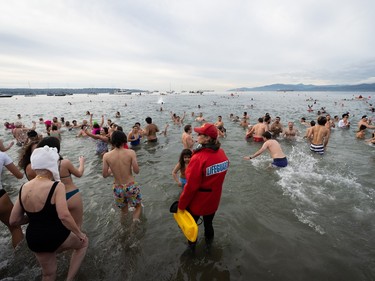 People participate in the Polar Bear Swim on New Year's Day at English Bay Beach in Vancouver, B.C., Monday, Jan. 1, 2024.