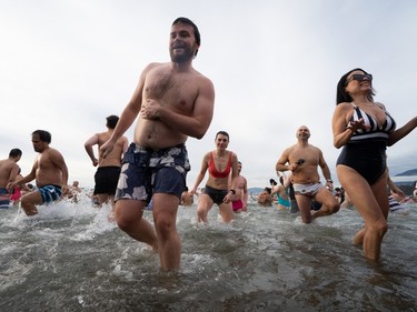 People participate in the Polar Bear Swim on New Year's Day at English Bay Beach in Vancouver, B.C., Monday, Jan. 1, 2024.