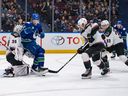 Arizona Coyotes goaltender Connor Ingram stops a shot as Matt Dumba and Travis Dermott defend while Vancouver Canucks' Brock Boeser watches during the first period of an NHL game in Vancouver on Thursday, Jan. 18, 2024.