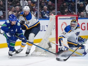 St. Louis Blues goalie Joel Hofer (30) stops Vancouver Canucks' Elias Pettersson (40) as St. Louis' Kevin Hayes (12) watches during the first period on Wednesday night at Rogers Arena