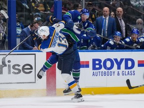 Vancouver Canucks' J.T. Miller, back right, checks St. Louis Blues' Alexei Toropchenko during the first period at Rogers Arena on Wednesday night